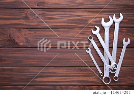 Combination wrenches for repair on brown wooden background 114624293