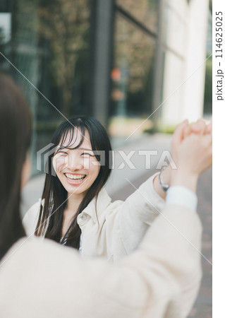 久しぶりに会う友達と再会した若い女性 114625025