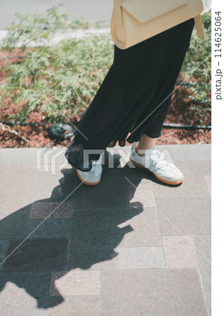 街を歩く若い女性の足下 114625064