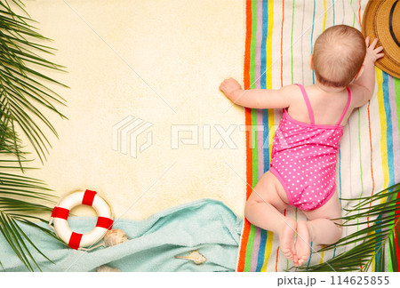 Cute baby girl lying on belly with beach accessories. Holidays at sea with baby, summer concept Cute baby girl lying on belly with beach accessories. Holidays at sea with baby, summer concept 114625855