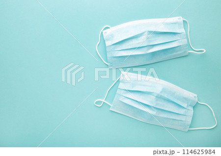 Medical used masks on a mint background with copy space. Coronavirus 114625984