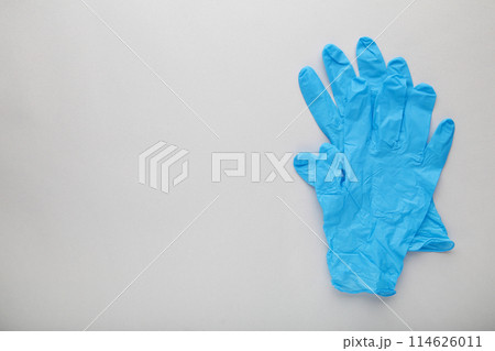 Blue medical gloves on a grey background Blue medical gloves on a grey background 114626011