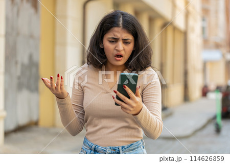 Indian woman use smartphone loses receive bad message mail news loss fail outdoors on city street Indian woman use smartphone loses receive bad message mail news loss fail outdoors on city street 114626859