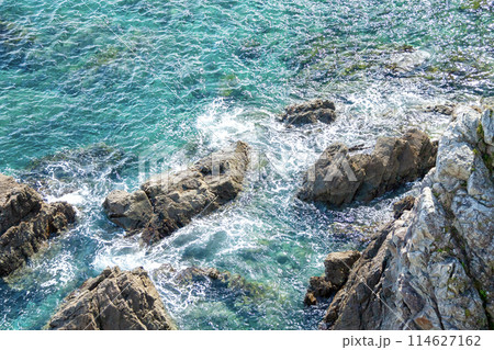 透明度の高い海の岩礁に打ち寄せる波 114627162