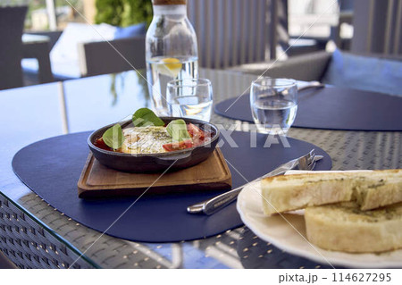 medium sized woman in peach fuzz dress eating Shakshouka in modern restaurant medium sized woman in peach fuzz dress eating Shakshouka in modern restaurant 114627295