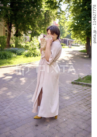 plus size woman in peach fuzz dress with hat having fun on morning city streets 114627778