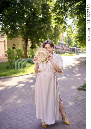 plus size woman in peach fuzz dress with hat having fun on morning city streets plus size woman in peach fuzz dress with hat having fun on morning city streets 114627780