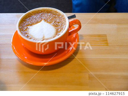 オレンジのコーヒーカップに入ったラテ オレンジのコーヒーカップに入ったラテ 114627915