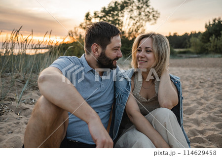 woman and man spending romantic time together on beach on sunset woman and man spending romantic time together on beach on sunset 114629458
