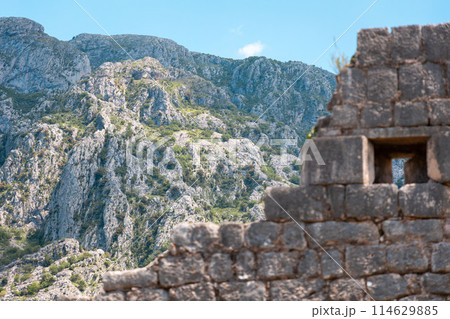 View from below of the old medieval ruined fortress of St. John in Kotor, Montenegro. Beautiful mountain landscape in background. Historic excursion at resort View from below of the old medieval ruined fortress of St. John in Kotor, Montenegro. Beautiful mountain landscape in background. Historic excursion at resort 114629885