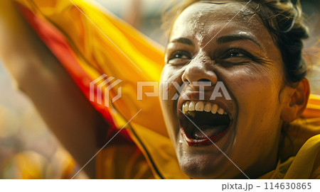 a soccer fan, their eyes shining with passion as they raise their scarf high in the air 114630865