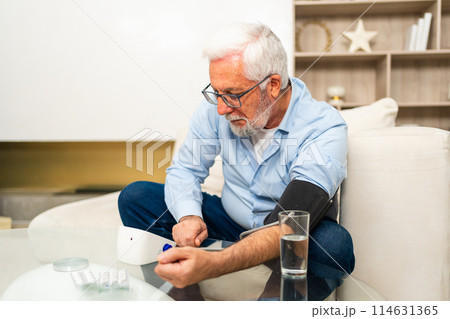 Hypertension problem in senior age. Old man measuring blood pressure with tonometer at home. Senior man have health problem making self checkup. Headache treatment of hypertension hypotension Hypertension problem in senior age. Old man measuring blood pressure with tonometer at home. Senior man have health problem making self checkup. Headache treatment of hypertension hypotension 114631365