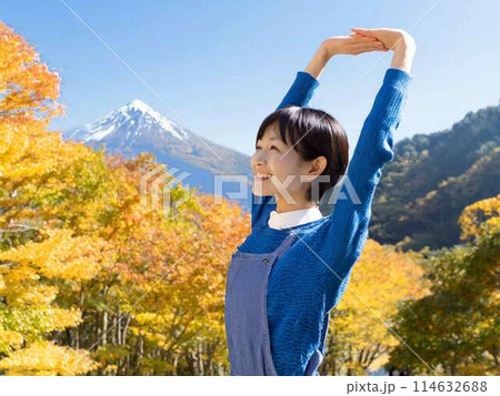 紅葉を背景にストレッチをする女性 114632688