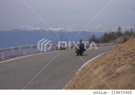 白馬連山をバックに美ヶ原スカイラインを走るオートバイ 白馬連山をバックに美ヶ原スカイラインを走るオートバイ 114633488