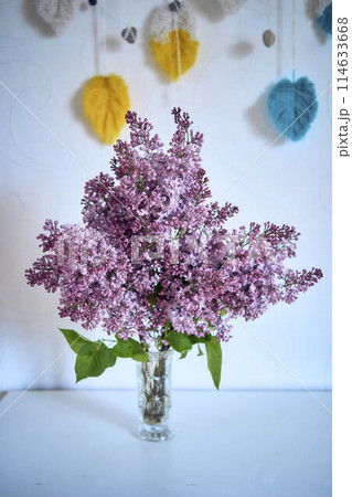 a bouquet of lilacs in a crystal vase in the interior 114633668