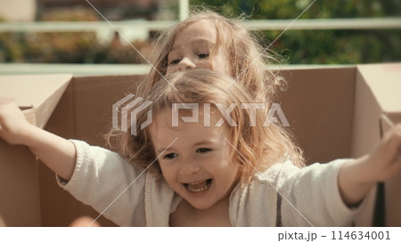 Little girls play with cardboard boxes. New home move or logistics concepts Little girls play with cardboard boxes. New home move or logistics concepts 114634001