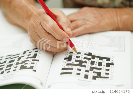 elderly woman playing sudoku puzzle game for treatment dementia prevention and Alzheimer disease. elderly woman playing sudoku puzzle game for treatment dementia prevention and Alzheimer disease. 114634176