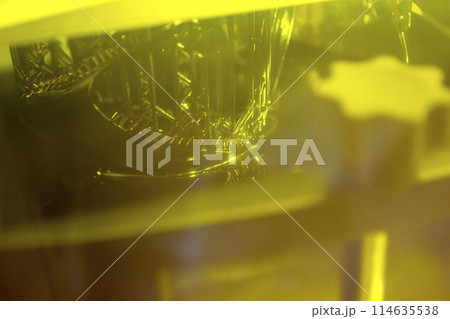 Working of photopolymer sla 3D printer. Platform with building object lowered into liquid photopolymer resins and hardened under ultraviolet laser. Progressive additive technology. 3D printer printing Working of photopolymer sla 3D printer. Platform with building object lowered into liquid photopolymer resins and hardened under ultraviolet laser. Progressive additive technology. 3D printer printing 114635538