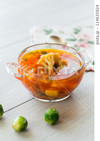 vegetable soup with Brussels sprouts and cauliflower, in a glass plate on a wooden table vegetable soup with Brussels sprouts and cauliflower, in a glass plate on a wooden table 114635924