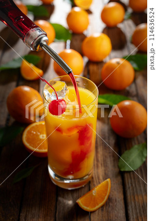 Classic tequila sunrise cocktail on an old wooden table. 114636524