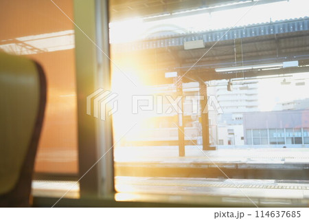 大阪環状線の電車から見える駅に差し込む夕日 114637685