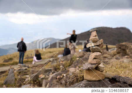 【箱根】駒ヶ岳山頂に積まれた石と風景を眺める観光客 114638037