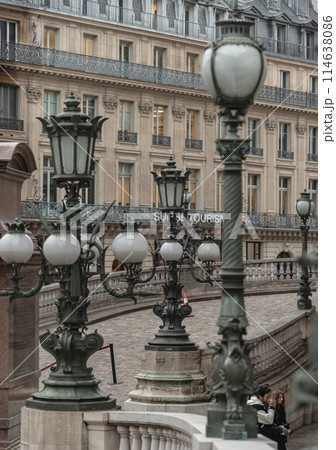 Vintage lamp posts on with white handrail with the historic building in background at The opera house Palais Garnier. 114638086