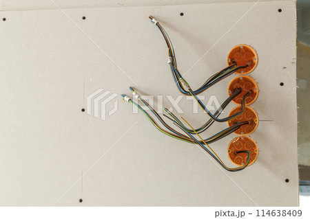 New electrical installation, socket plastic boxes and electrical cables on the wall, renovation concept. Electrical wiring installation. 114638409