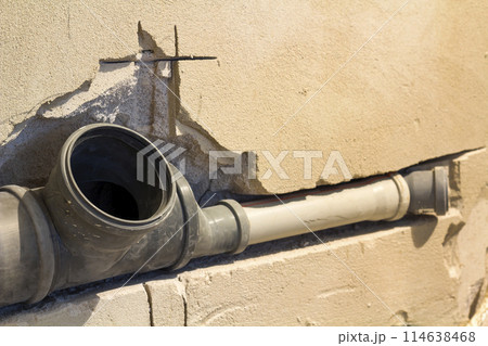Installation of sewer pipes in a bathroom of an apartment interior during renovation works. Gray plastic drain pipe for used water. 114638468