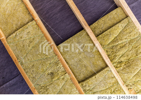Thermal insulation mineral rock wool installation at the new building attic ceiling 114638498