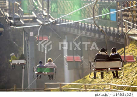 Ski lift with tourists in seats in ski resort 114638527