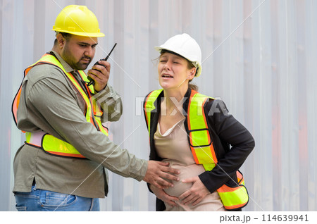 Factory engineer or worker man helping pregnant businesswoman suffering belly ache at warehouse distribution center while working together in front white container Factory engineer or worker man helping pregnant businesswoman suffering belly ache at warehouse distribution center while working together in front white container 114639941