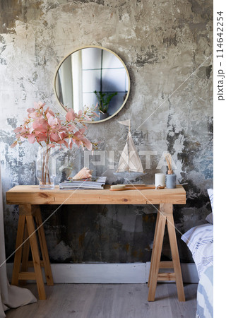 A modern wooden table, a round mirror, flowers and accessories for the house with a copy on the background of the wall in the style of the grange loft. Boho style 114642254