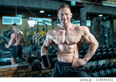 muscular bodybuilding athlete with perfect body holding protein or whey jar mockup in gym, athletic man with torso in fitness club holding sport nutrition and supplement 114643531
