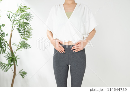 お腹を気にする女性 114644789