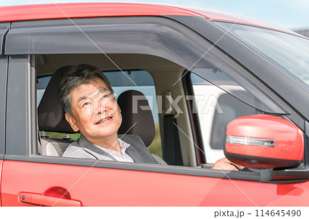 自動車の運転をする笑顔の高齢者ドライバーの男性 自動車の運転をする笑顔の高齢者ドライバーの男性 114645490