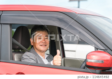 自動車の運転をする笑顔の高齢者ドライバーの男性 自動車の運転をする笑顔の高齢者ドライバーの男性 114645492