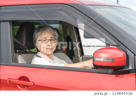 自動車の運転をする笑顔の高齢者ドライバーの女性 自動車の運転をする笑顔の高齢者ドライバーの女性 114645536