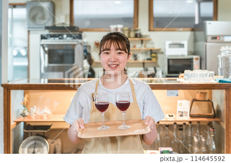 飲食店・バー・居酒屋・ワインバー・バル・ワインショップで赤ワインを持つ若い女性スタッフ 飲食店・バー・居酒屋・ワインバー・バル・ワインショップで赤ワインを持つ若い女性スタッフ 114645592