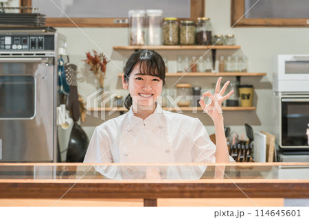 カフェ・居酒屋・飲食店の厨房で働く調理師のアジア人女性 カフェ・居酒屋・飲食店の厨房で働く調理師のアジア人女性 114645601