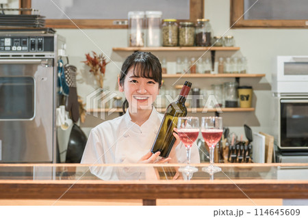 飲食店・バー・居酒屋・ワインバー・バル・ワインショップで赤ワインを持つ女性(ソムリエ・シェフ) 114645609