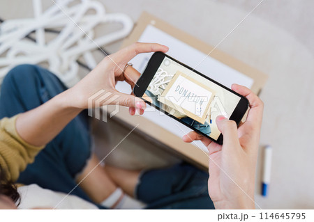 Asian woman use mobile phone to take photo of donation box to encourage friend on social media to donate Asian woman use mobile phone to take photo of donation box to encourage friend on social media to donate 114645795