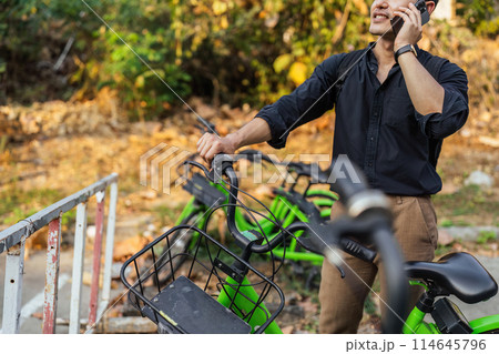 business man holding mobile using bike rental digital phone app scanning qr code to rent electric bicycle in city business man holding mobile using bike rental digital phone app scanning qr code to rent electric bicycle in city 114645796