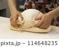 Close up of woman kneading dough, Hands forming bread in an organic bakeryHands forming bread in local bread store 114648235
