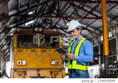 Man railway technician engineer wearing safety uniform and safety helmet holding tablet. 114650899