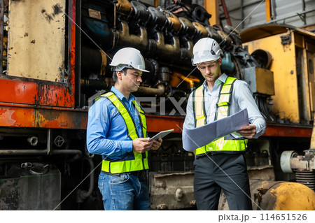 Railway technician engineer wearing safety uniform and safety helmet holding tablet and blueprint Railway technician engineer wearing safety uniform and safety helmet holding tablet and blueprint 114651526