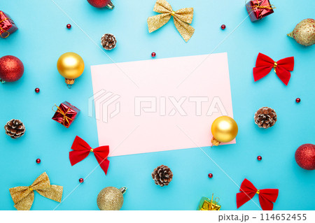 Christmas composition with gold and red decoration on blue background with copy space Christmas composition with gold and red decoration on blue background with copy space 114652455