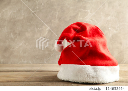 Santa Claus red hat on grey concrete background Santa Claus red hat on grey concrete background 114652464