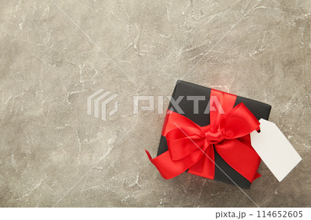 Black gift box with sale tag on grey concrete background 114652605