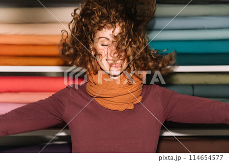 Stylish woman with curly hair in craft textile store, design concept Stylish woman with curly hair in craft textile store, design concept 114654577